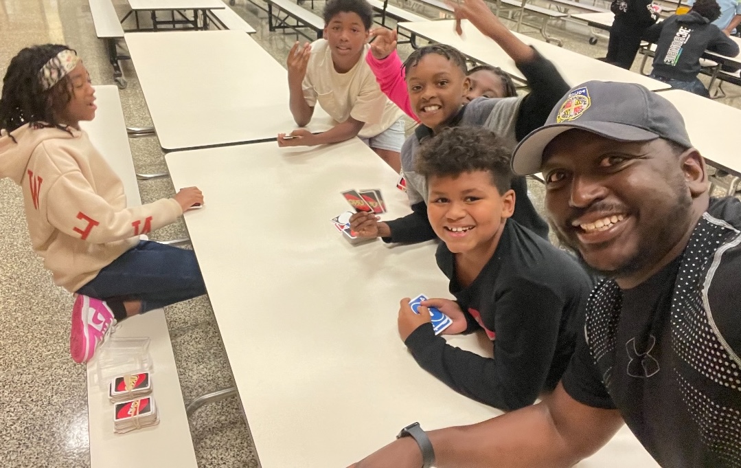 Bryan Dixon taking a selfie with smiling students in school cafeteria